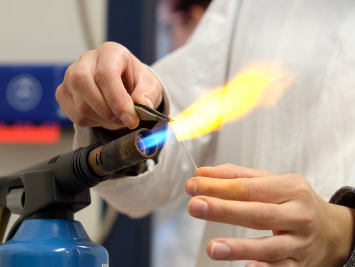 An einem Brenner wird ein kleines Glasröhrchen geformt. 