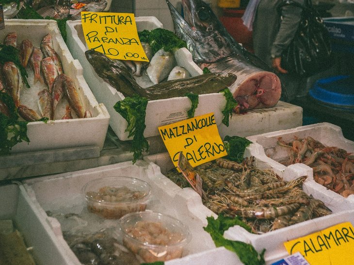 Es liegen verschiedene Fische auf Eis in Boxen.