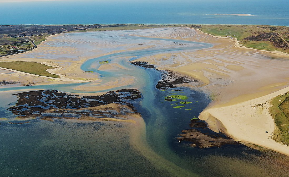 Luftaufnahme des Königshafens, einer Wattenmeerbucht im Norden der Insel Sylt bei Niedrigwasser mit dunklen Muschelbänken, Prielen, Watt und Stränden im Jahr 2024.